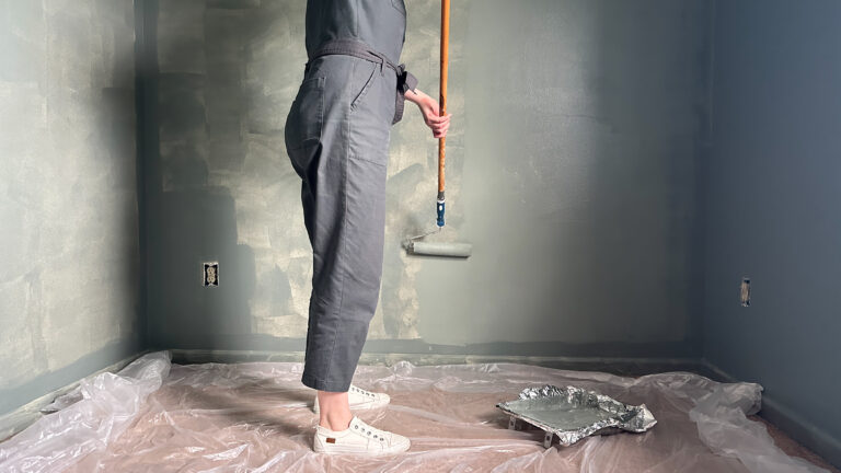 using a long roller to paint a wall