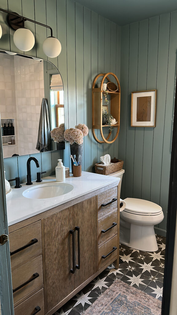 blue bathroom with black and white star tile and wood vanity